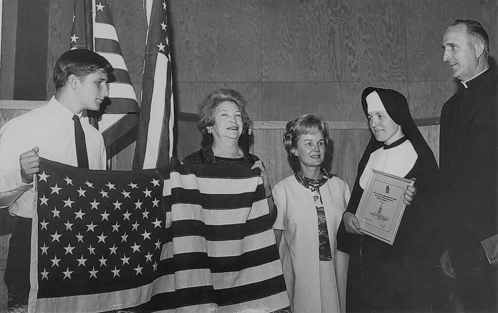 While Principal of Notre Dame School, Chico in 1967, Sister Julie Marie Thorpe, SNDdeN accepted a flag flown over the White House that was awarded by the American Legion.