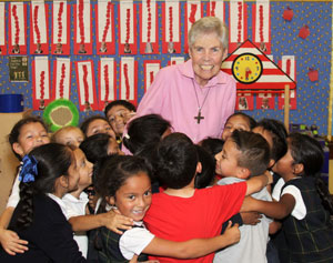 Sister Judy Flahavan in a group hug with kindergarteners