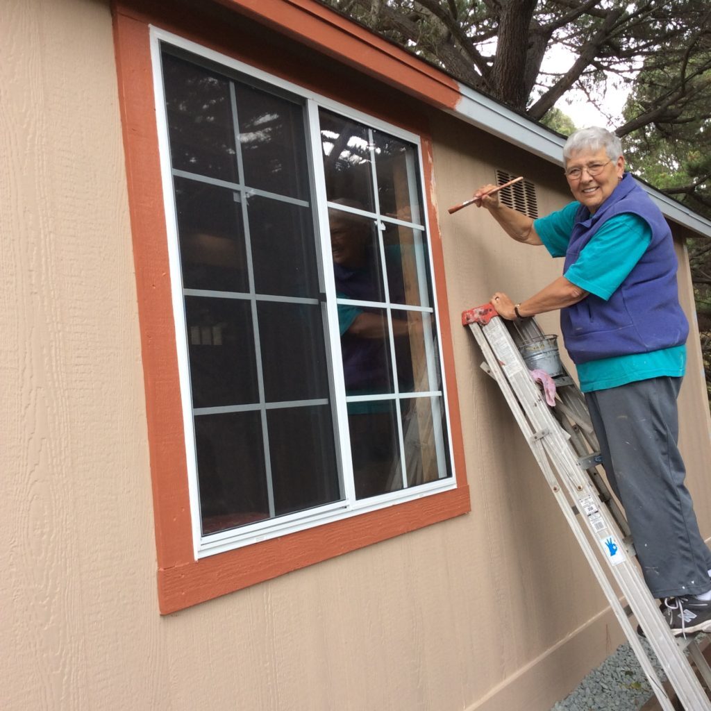 Sister Michelle paints a new building at the Carmel House of Prayer.
