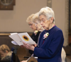 Sr. Nancy Rowen reading from church program Emmanuel Jubilee 2026